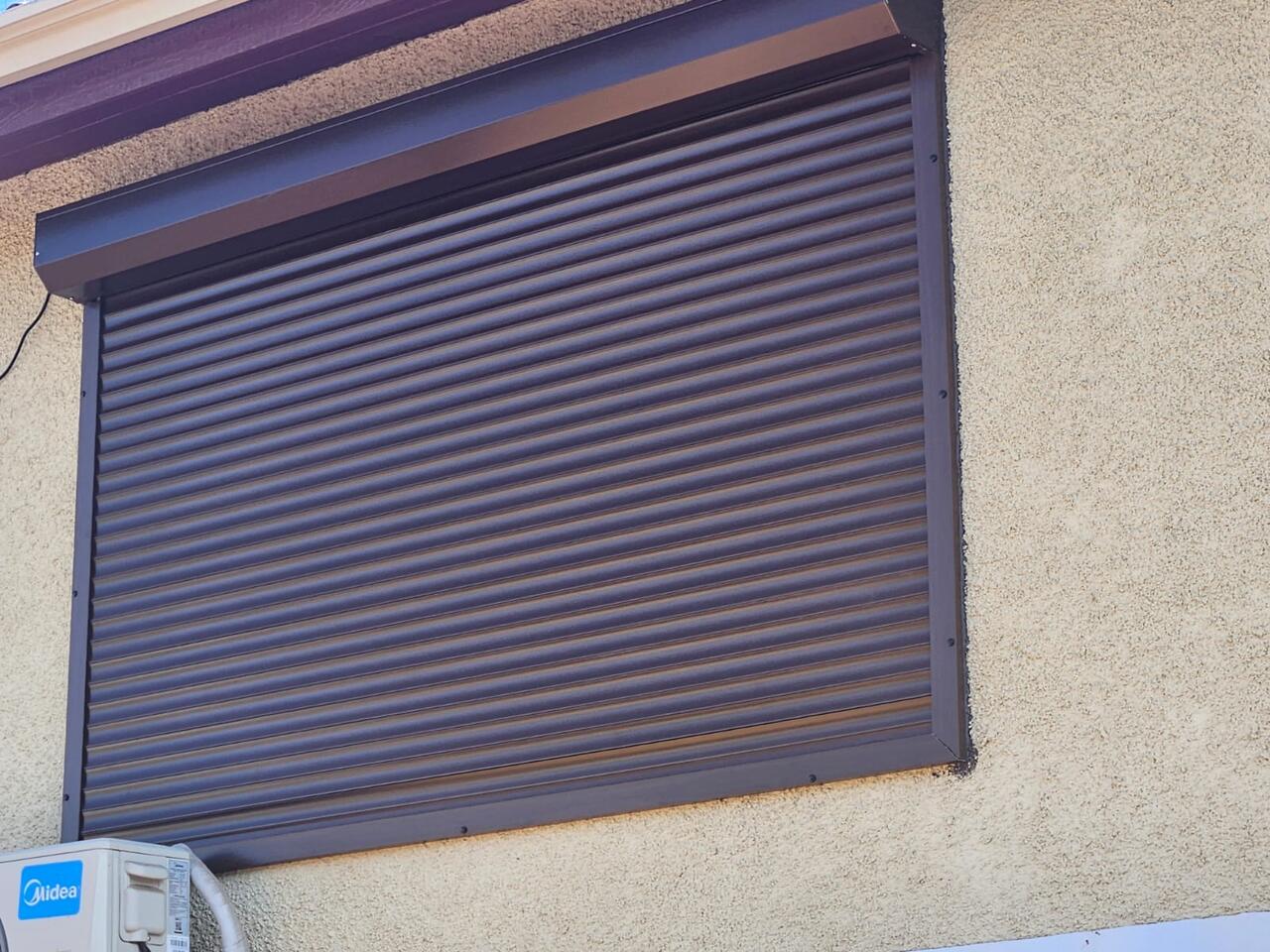 Fachada residencial con persianas de aluminio café