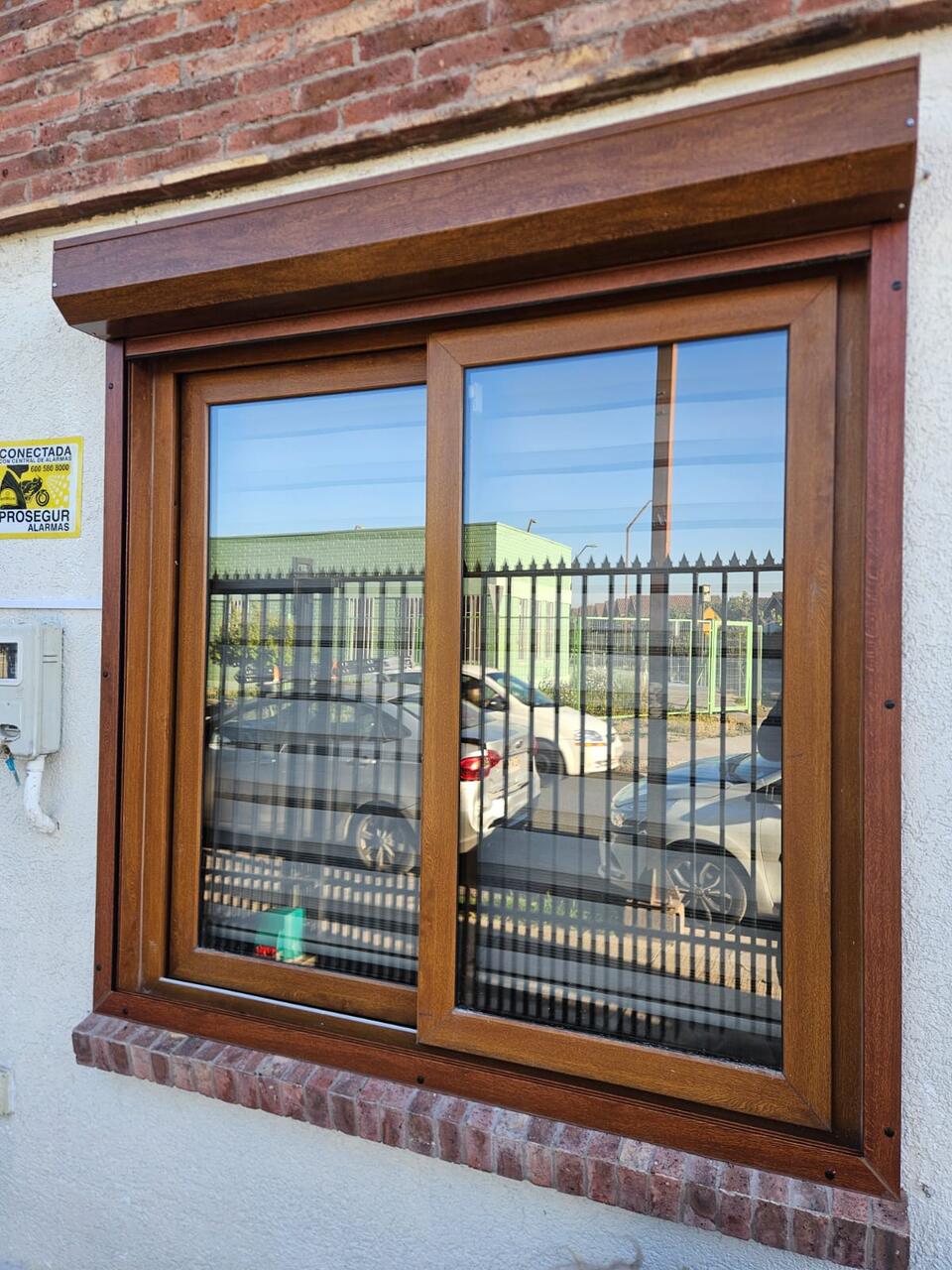 Ventana con marco símil madera y persiana de aluminio